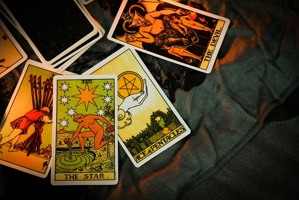 Tarot reading with tarot card background and candlelight on the table.