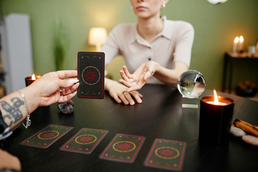  Close-up of female fortune teller reading tarot cards for a young woman visiting at a seance