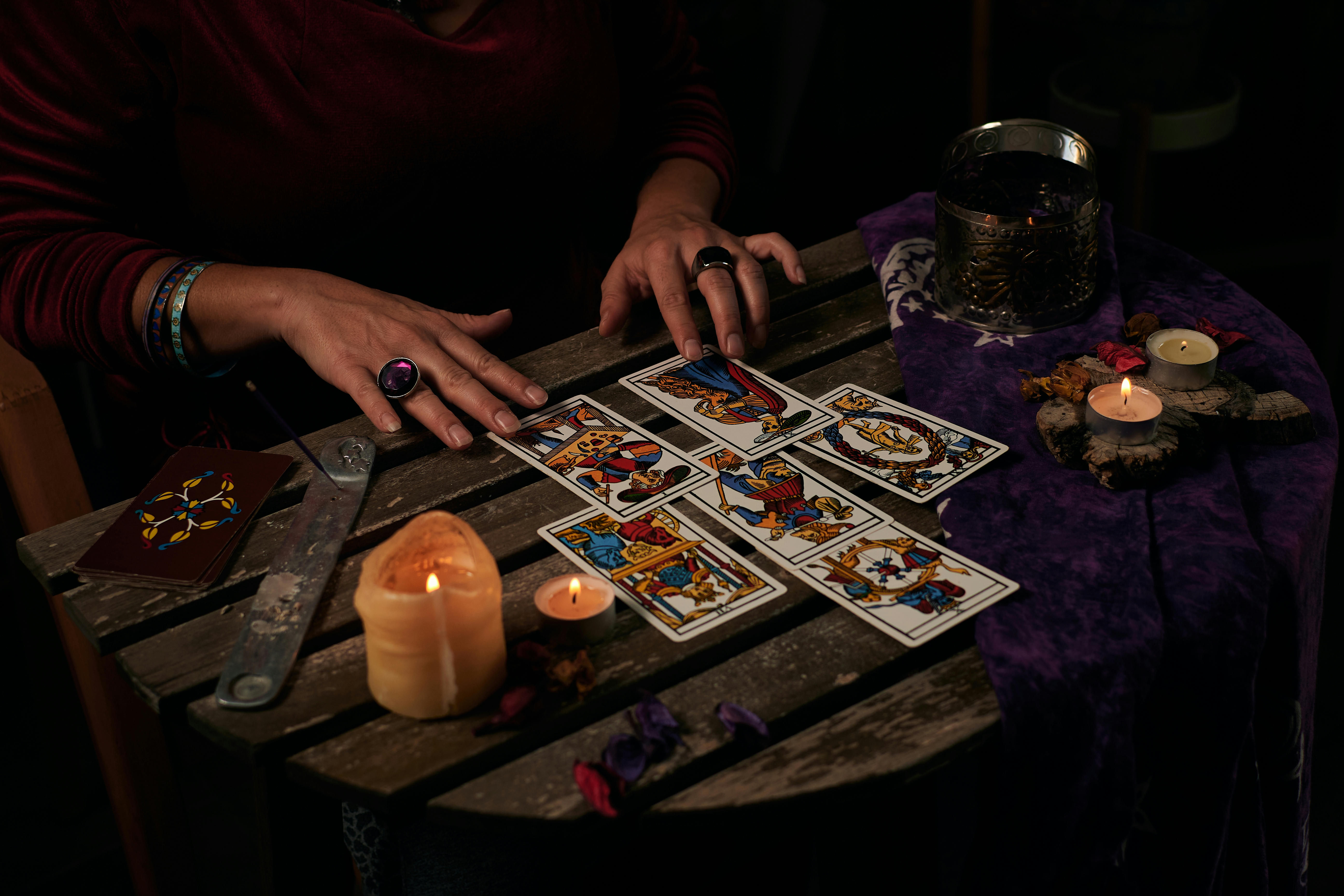 A table with a candle and six face up tarot cards