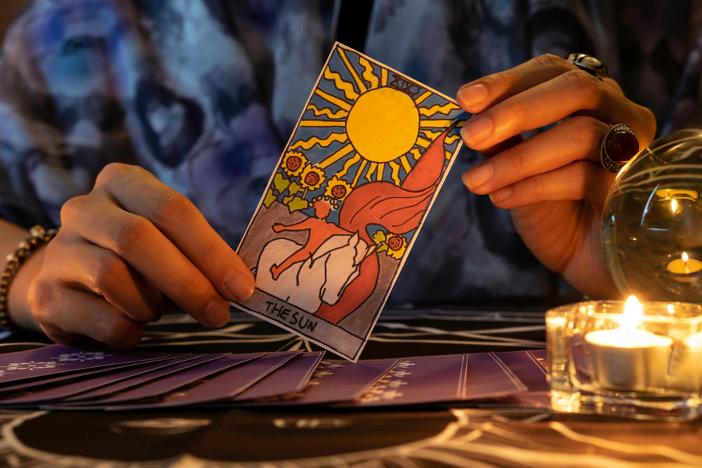 psychic holding the sun tarot card