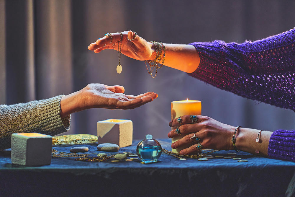  A psychic reader during palmistry around candles and other magical accessories.