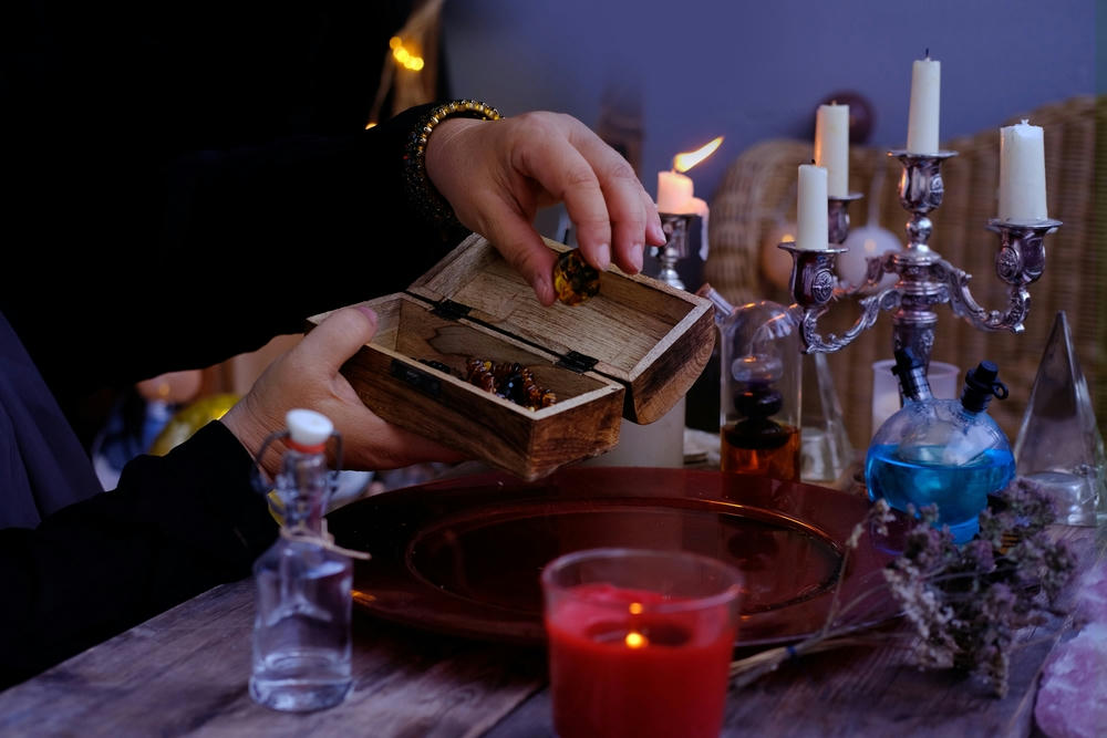 Spiritualistic seance in the salon of soothsayer, hands of female psychic pull out of the wooden box.