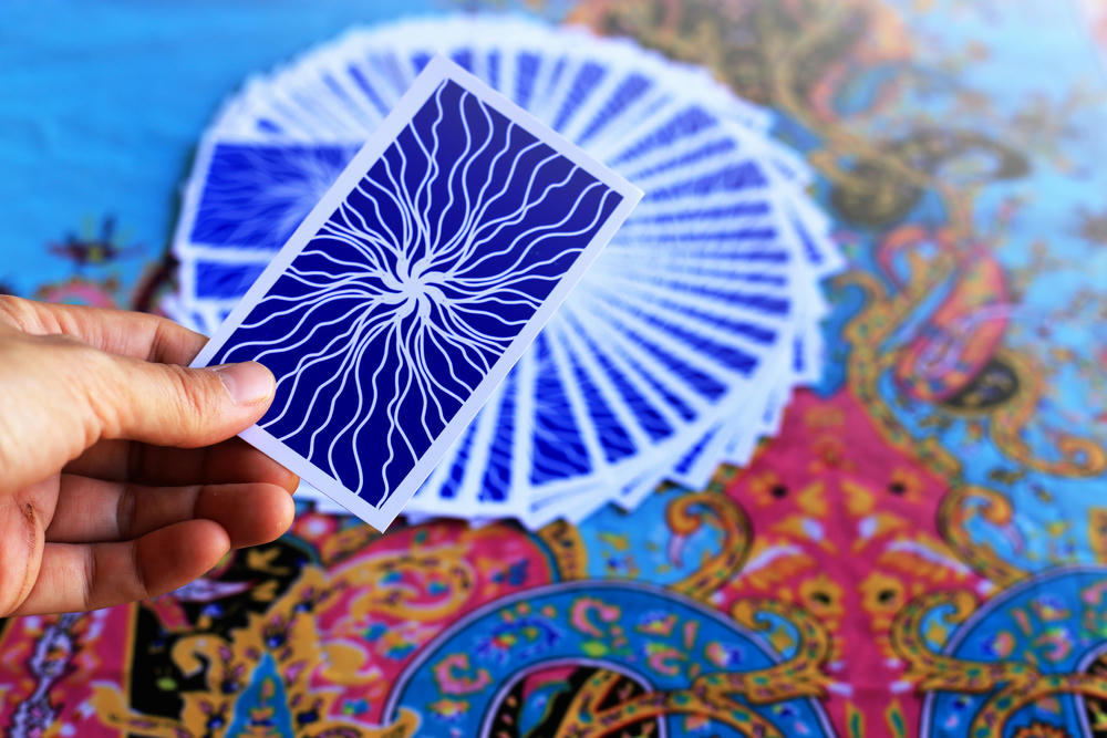 Tarot card reading on cloth for fate or fortune-telling through the design of the blue card.