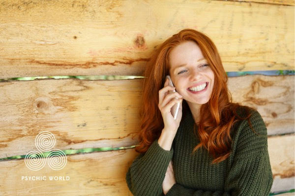 woman with green shirt smiling on the phone