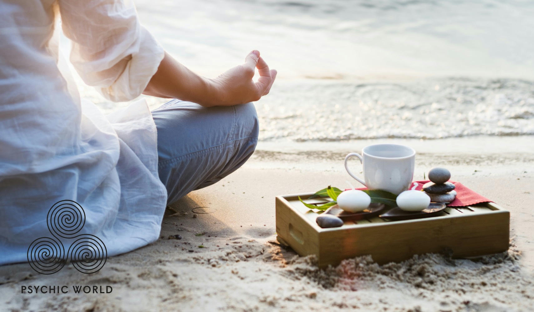 woman meditating on the sand drinking tea